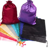 A collection of satin drawstring storage bags in various colors including maroon, purple, black, and teal.