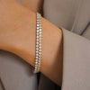 Primer plano de una delicada pulsera de tenis de diamantes puesta en una muñeca.