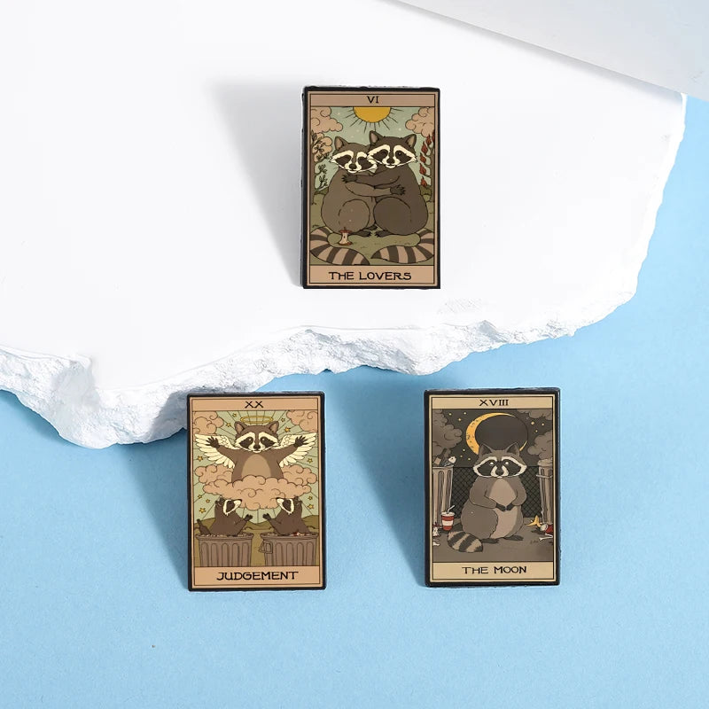 A set of three tarot card enamel pins featuring The Lovers, Judgement, and The Moon