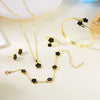 A set of five gold-colored bracelets and necklaces featuring black enamel plum blossoms.