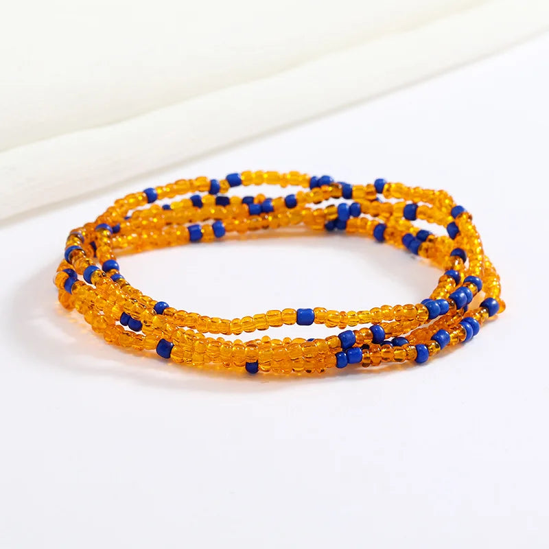 Una pila de cuentas de semillas naranjas y azules formando una cadena corporal tejida a mano flexible.