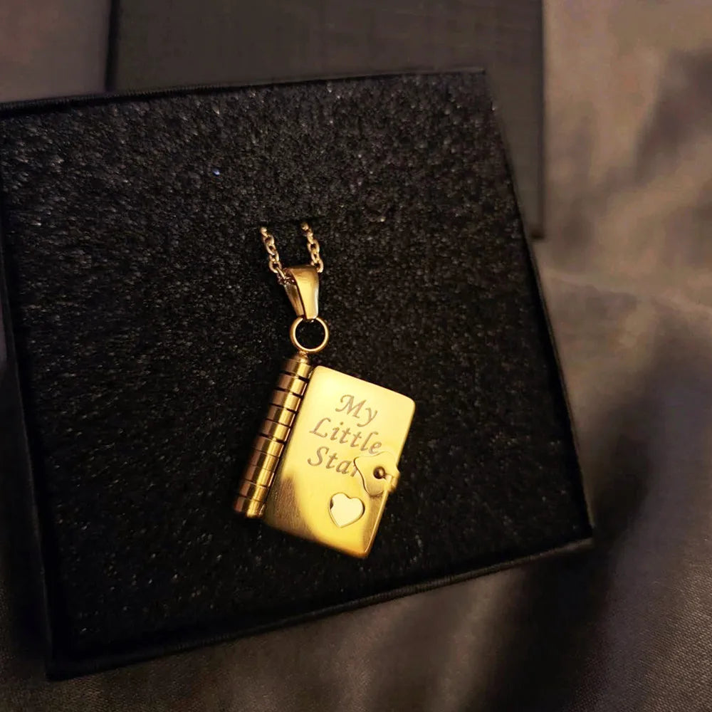 Goldenes Anhängerkettchen mit graviertem Herzanhänger auf einer schwarzen Samtbox.