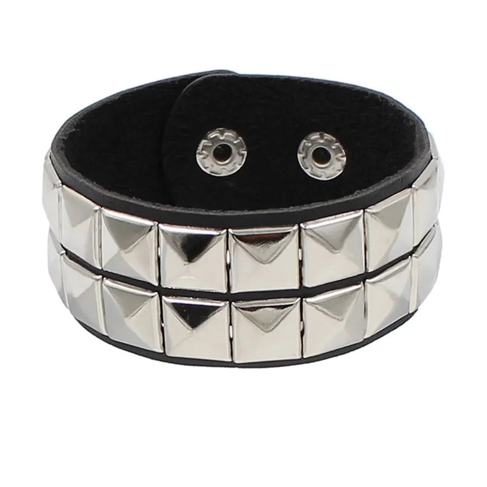 Un ensemble de bracelets en cuir cloutés style punk avec accents argentés et bandes en cuir noir.