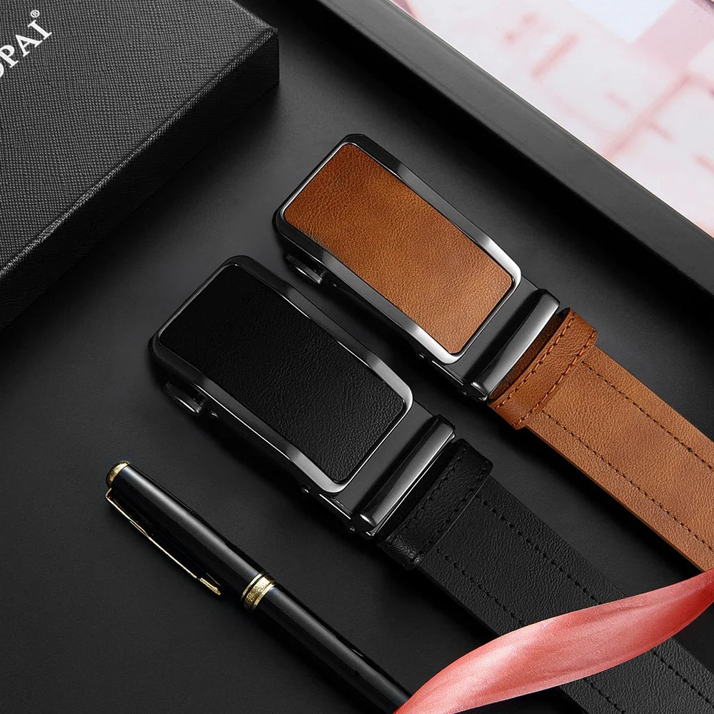 A black smartwatch and leather strap are displayed next to a black pen on a dark surface.