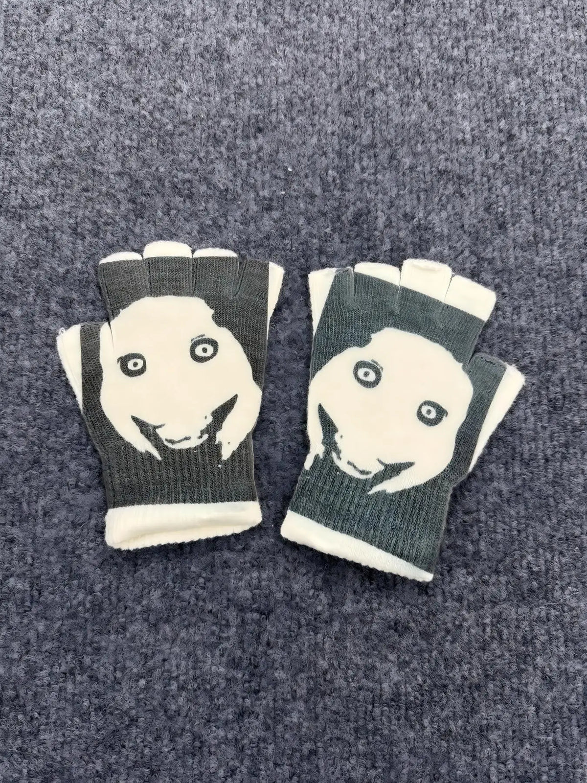 Pair of Y2K retro printed fingerless knit gloves featuring a white face design on a dark green background