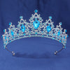 An elegant crystal rhinestone tiara and headband set featuring blue gemstones.