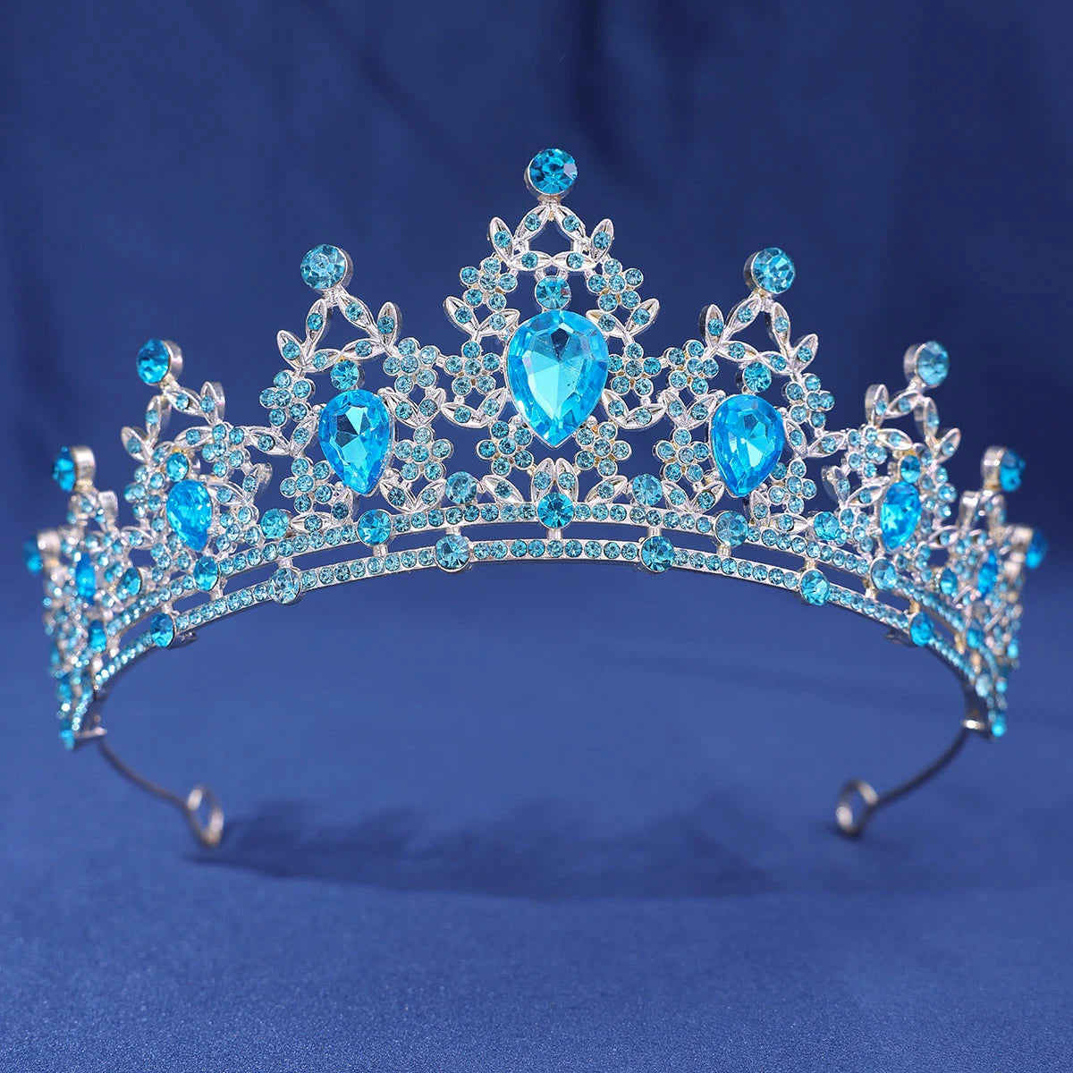 An elegant crystal rhinestone tiara and headband set featuring blue gemstones.