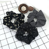 A set of three black knitted hair scrunchie headbands with various patterns and textures arranged on a white surface.