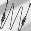A set of black metal link eyeglass straps with decorative clasps displayed against a white background.