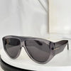 A pair of oversized pilot sunglasses with dark gray lenses and a translucent purple frame resting on a white surface.
