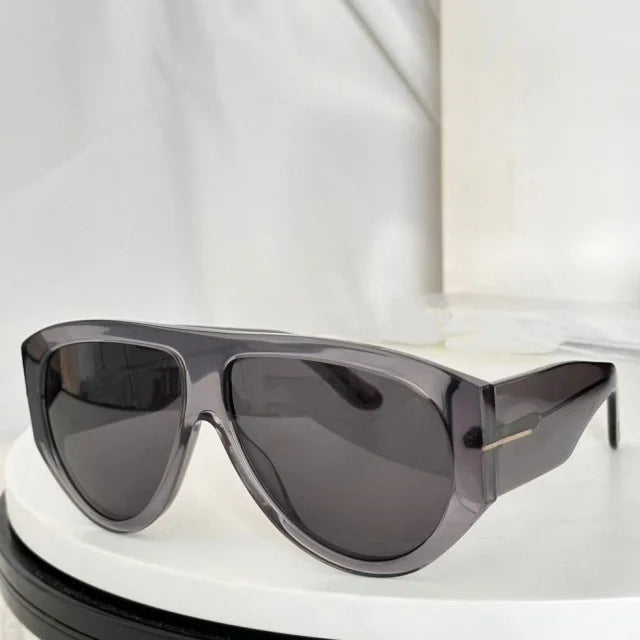 A pair of oversized pilot sunglasses with dark gray lenses and a translucent purple frame resting on a white surface.