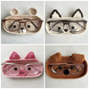 Four handmade crochet animal eyeglass storage cases featuring a bear, a fox, a pig, and a cat face.