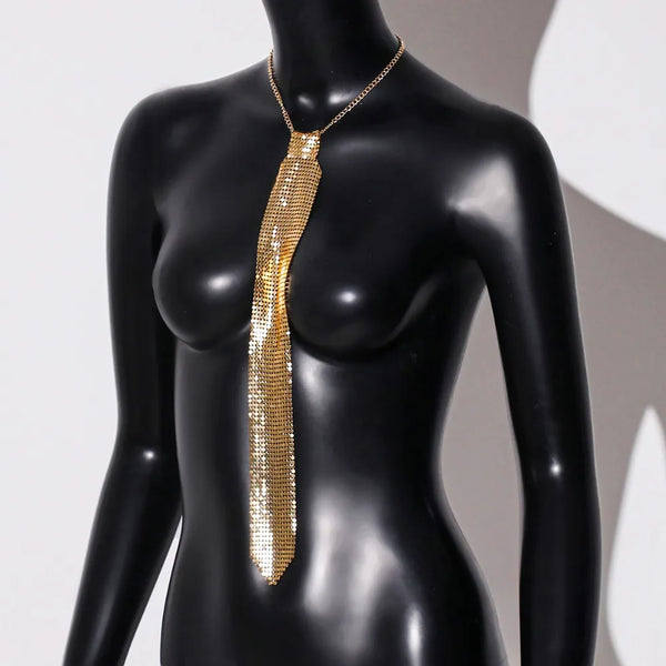 A gold crystal rhinestone sequin neck tie necklace displayed on a black mannequin.