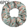 Un juego de seis gomas de tela con estampado floral de satén en color verde salvia.
