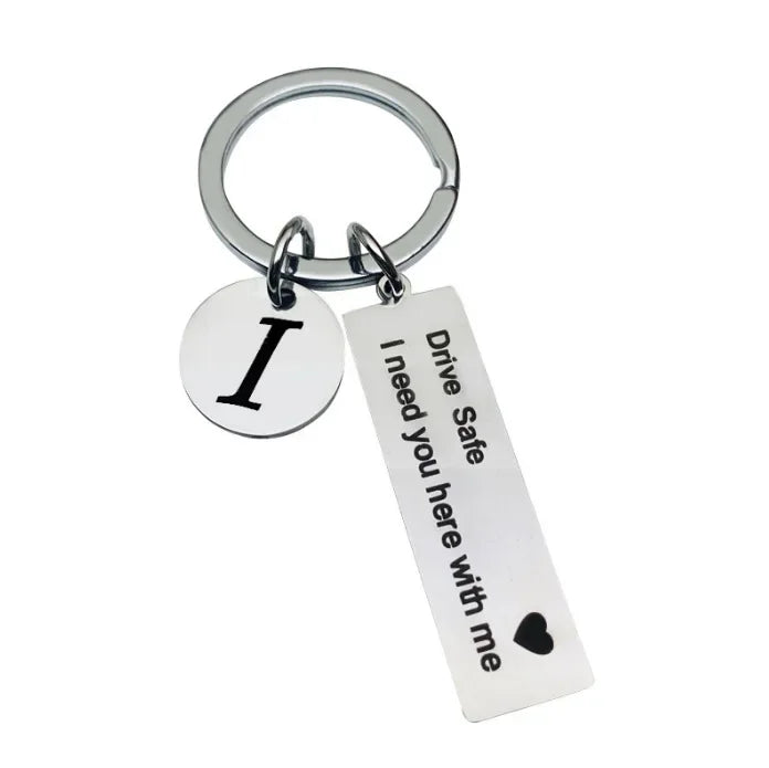 Silver keychain with an initial I and a tag that reads Drive Safe I need you here with me