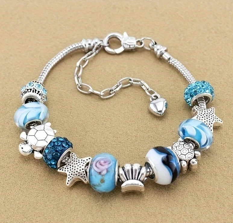 Silver bracelet featuring multi-element beads in shades of blue and white with star and heart charms