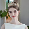 Una mujer vistiendo una elegante diadema de tiara de diamantes barrocos y un vestido blanco.