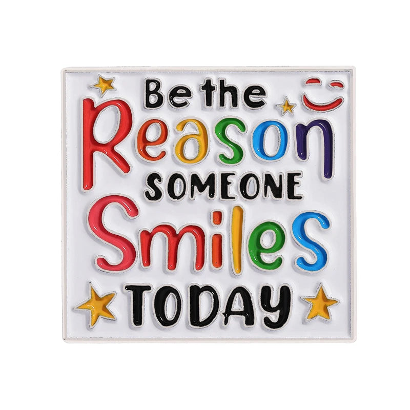 An enamel lapel pin featuring the text Be the Reason Someone Smiles Today in colorful lettering.