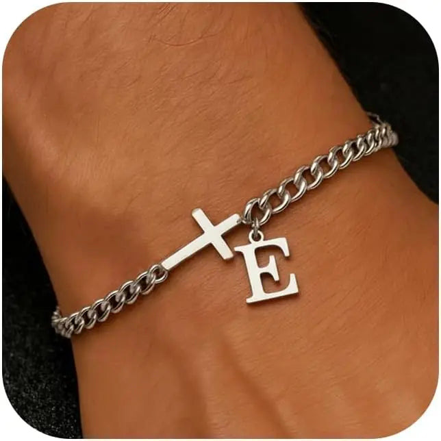 A close-up of a personalized stainless steel cross Cuban chain bracelet worn on a wrist.