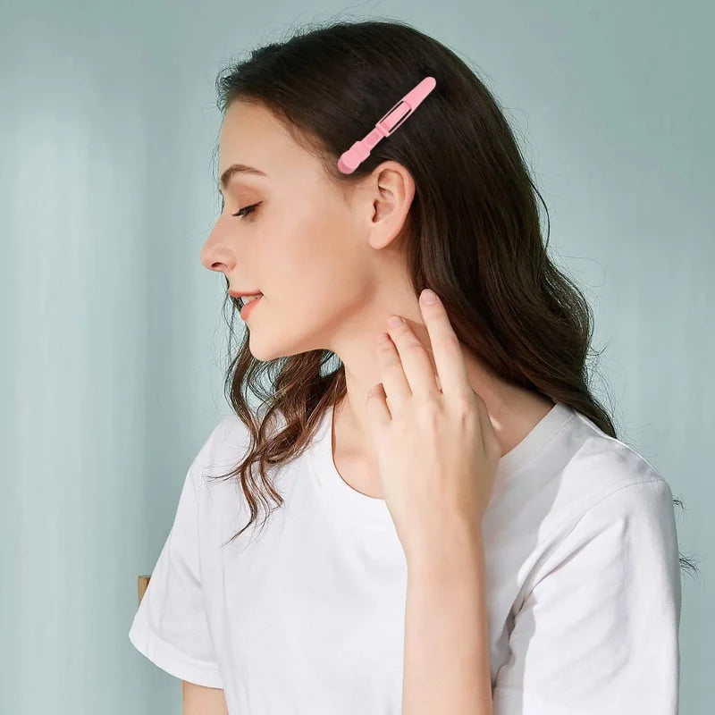 A woman is using a pink alligator hair sectioning clip on her hair.