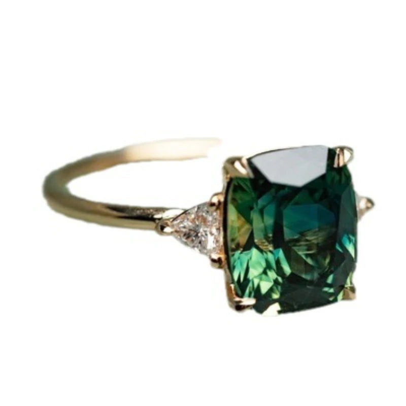 Vintage square gemstone four-claw ring featuring a deep green emerald cut stone and diamond accents.
