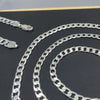 Silver geometric face chain necklace displayed on a dark background