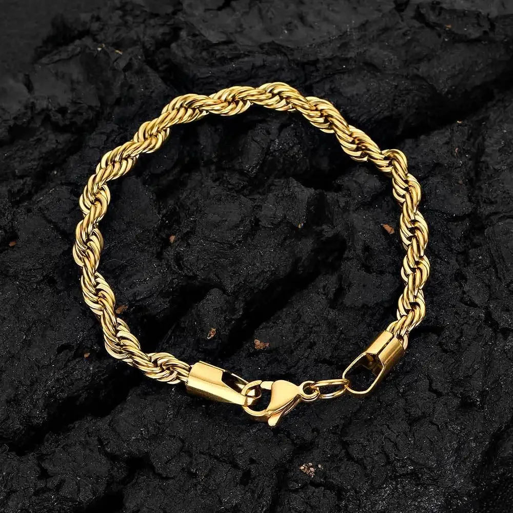 A gold-colored stainless steel twisted chain bracelet laid on a dark, textured surface.
