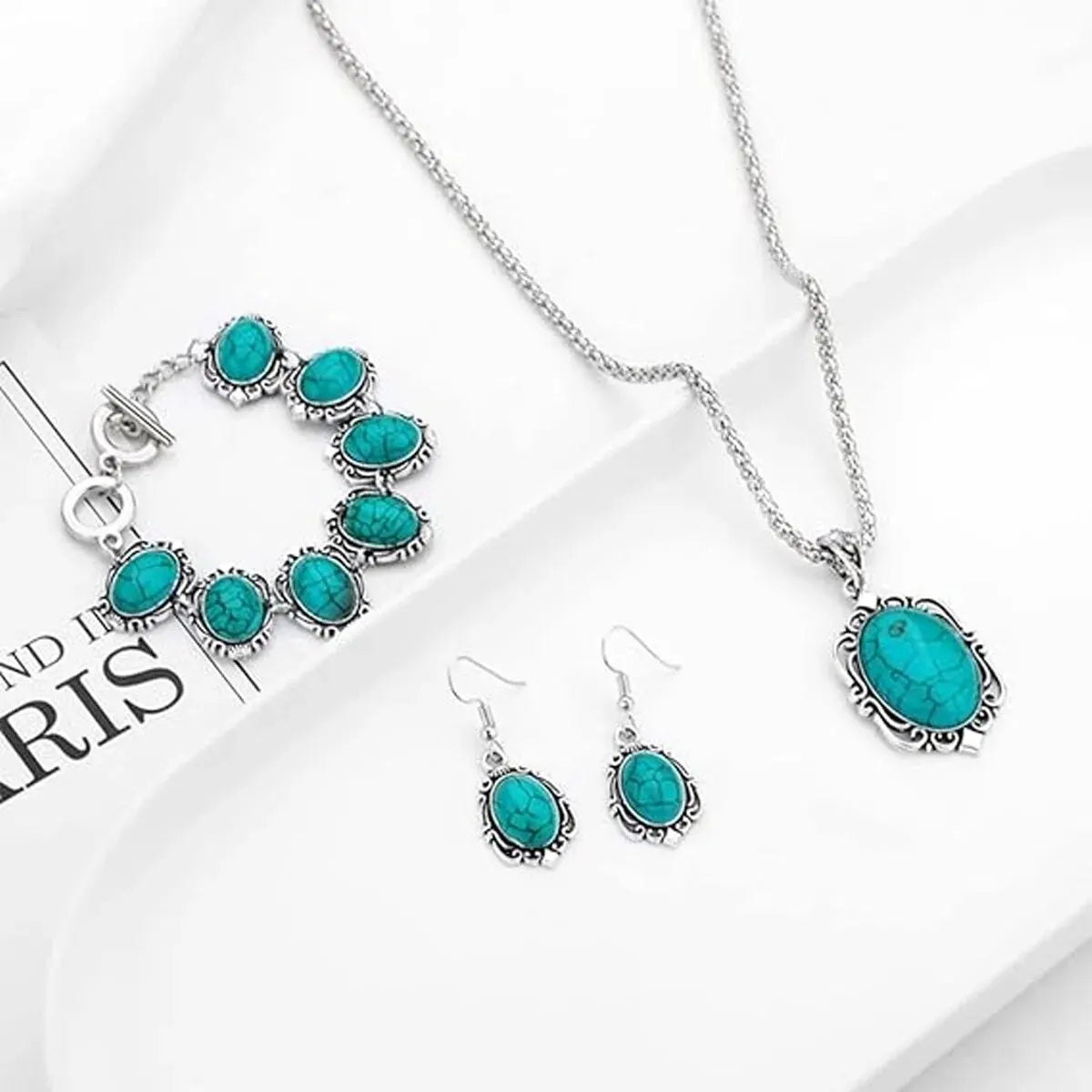 A set of vintage turquoise stone jewelry including a necklace, earrings, and bracelet displayed on a white background.