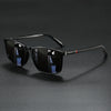 Black classic square sunglasses with black frames and dark lenses resting on a dark surface.