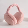 A soft pink plush fur ear warmer with a looped headband is shown against a white background.