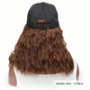 Back view of a brown wavy wig with a black adjustable cap and white hairpiece.