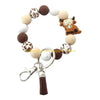 A silicone wristlet keychain featuring various brown and white patterned and solid colored cow-themed beads.