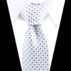 A light blue and yellow diamond patterned silk necktie worn under a white dress shirt.