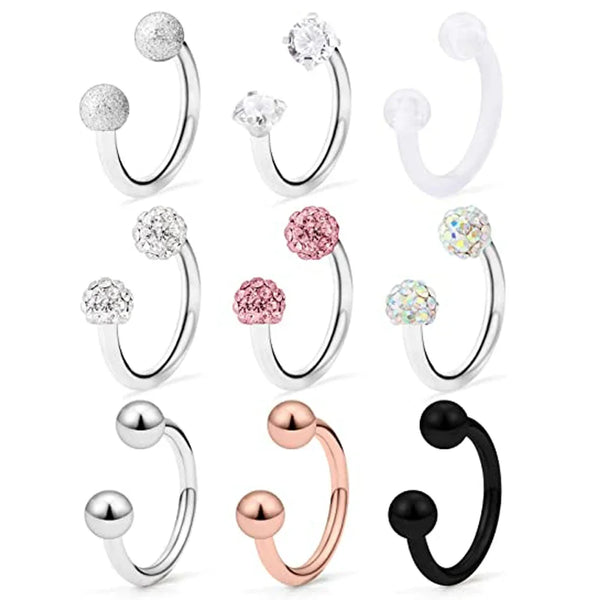 A set of crystal horseshoe barbell rings in silver, rose gold, and black surgical steel body jewelry.