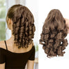 A close-up of a brown hair extension styled in curls and waves, shown from the back.