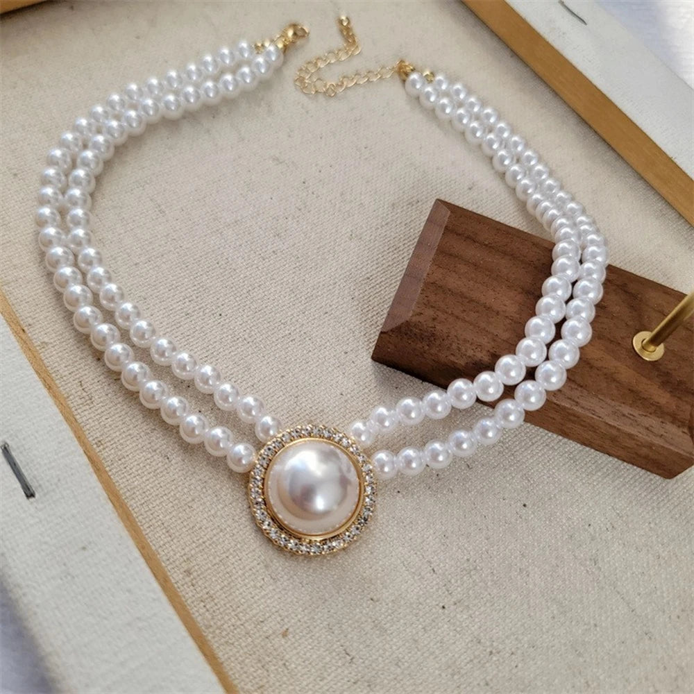 Collier délicat en perles et strass sur une surface en bois.