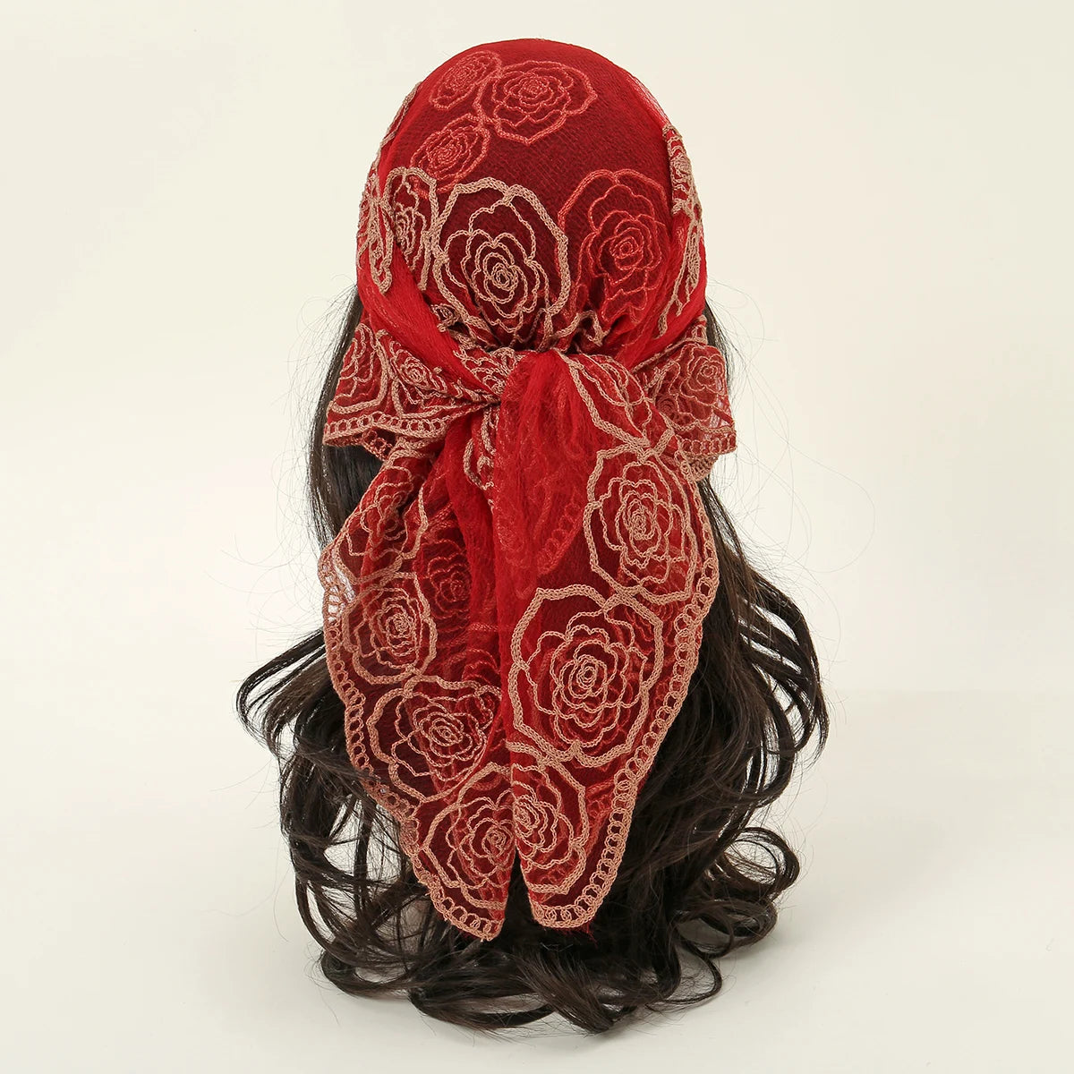 A vibrant red floral embroidered lace bandana headscarf tied around dark hair.