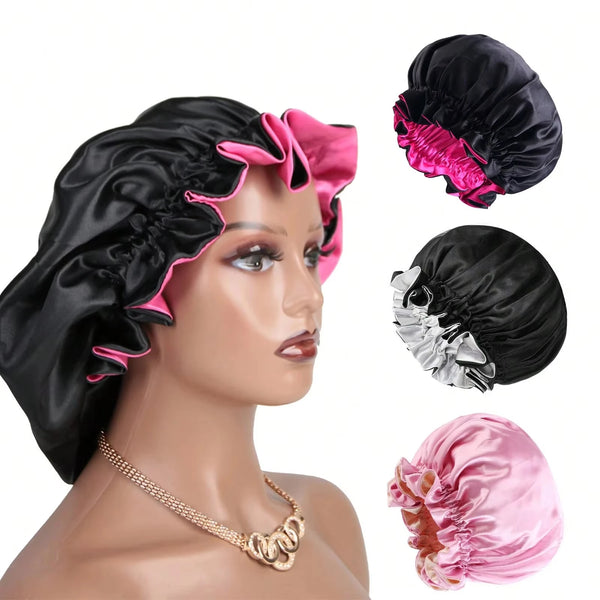 A black satin sleeping bonnet hair cap shown on a mannequin, with separate pieces of pink and silver fabric visible.