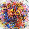 A pile of colorful disposable hair scrunchies in various bright colors like pink, yellow, blue, and red.