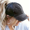 A blonde woman wears a black vintage mesh baseball cap with silver embroidery.