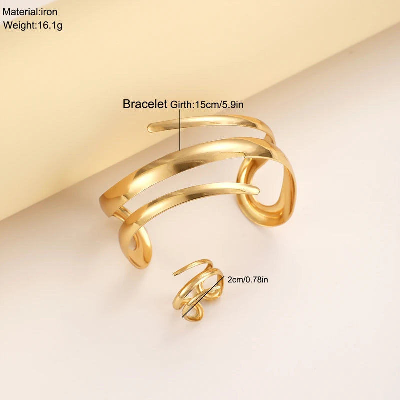 Un ensemble de bracelet et bague géométriques en or présenté sur un fond clair.