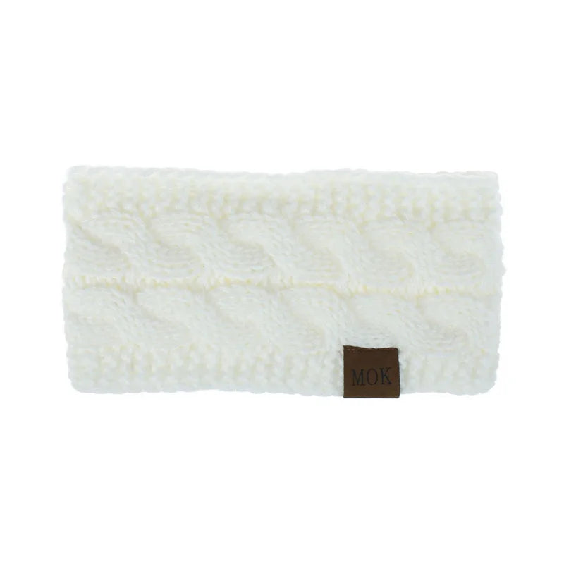 White plush winter ear warmer headband with a brown tag.
