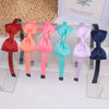 A display of nine decorative grosgrain ribbon hair bows in various shades of pink, red, blue, and purple.