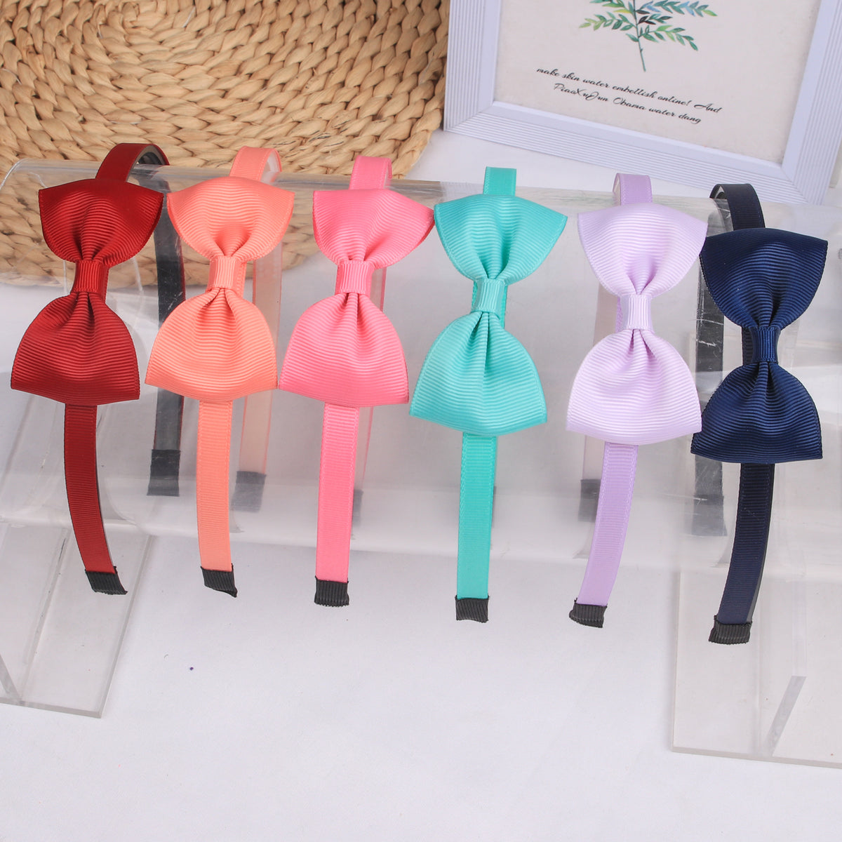 A display of nine decorative grosgrain ribbon hair bows in various shades of pink, red, blue, and purple.