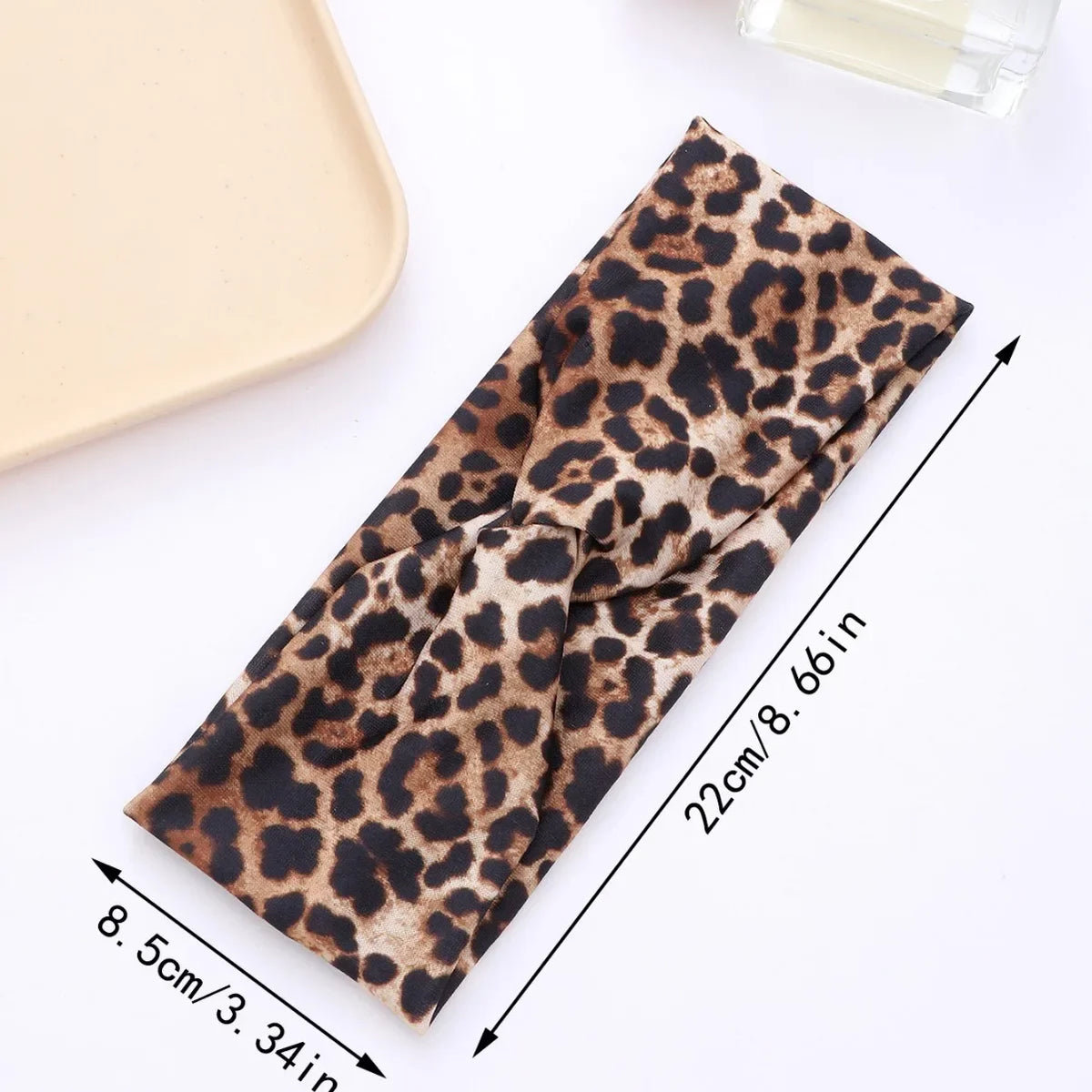A brown leopard print fabric headband shown flat with measurements.