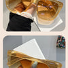 A pair of amber-tinted retro cat eye sunglasses being held by a hand against a white background.