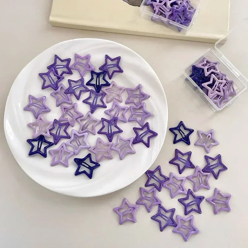 Purple and blue Y2K sweet star barrette hair clips arranged on a white plate and scattered on a surface.