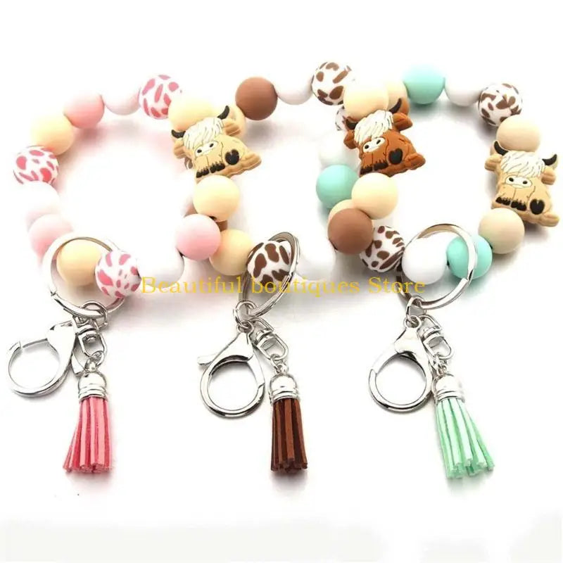 A set of silicone wristlets featuring cute Highland cow designs and tassel charms.