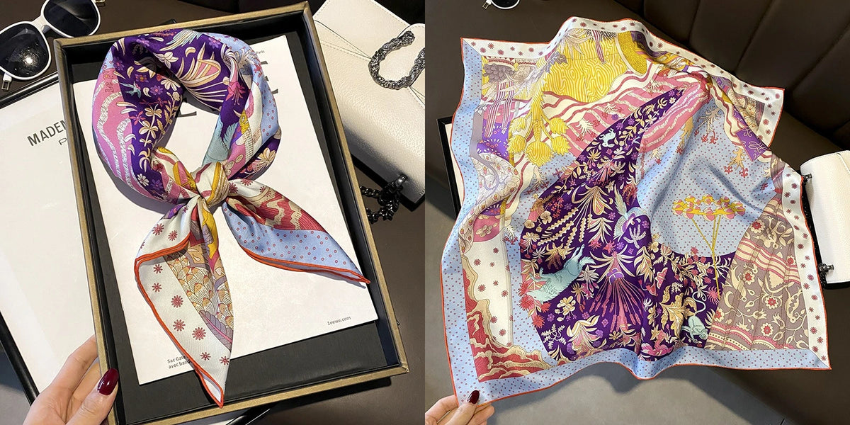 A purple and pink floral print silk scarf draped on a display card.