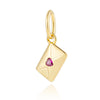 Un dije de color dorado en forma de diamante con una gema morada incrustada.